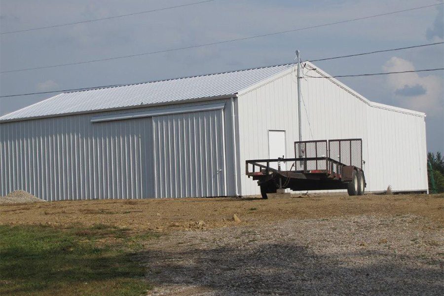 Contact - View of Metal Storage Building with a Trailer Next to It on a Farm Setting in Ohio